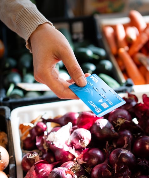 Individual using UNFCU Azure credit card at a farmers market.