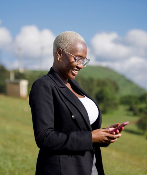 Individual looking at cellphone in nature.