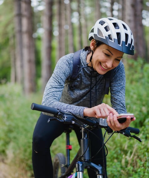 Individual looking at cellphone in nature.