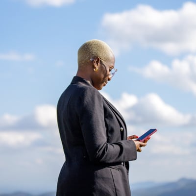 Individual looking at cellphone in nature.