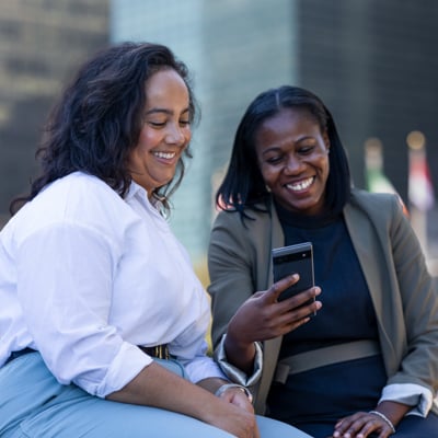 Two UNFCU staff looking at a cellphone on the United Nations campus.