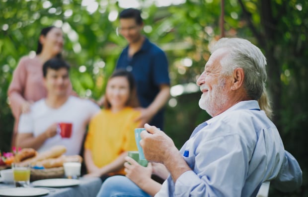 Group of individuals enjoying a family lunch outdoors.