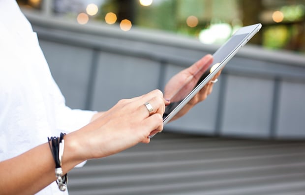 Individual looking at a tablet.