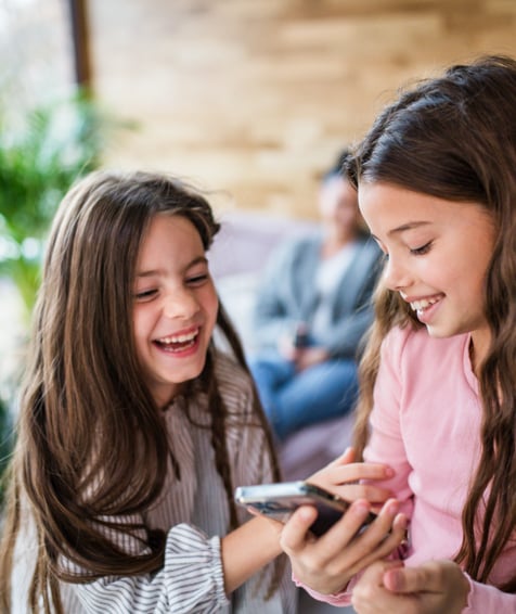 Two children playing with cellphone.