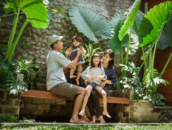 Two individuals and two children playing in back yard.