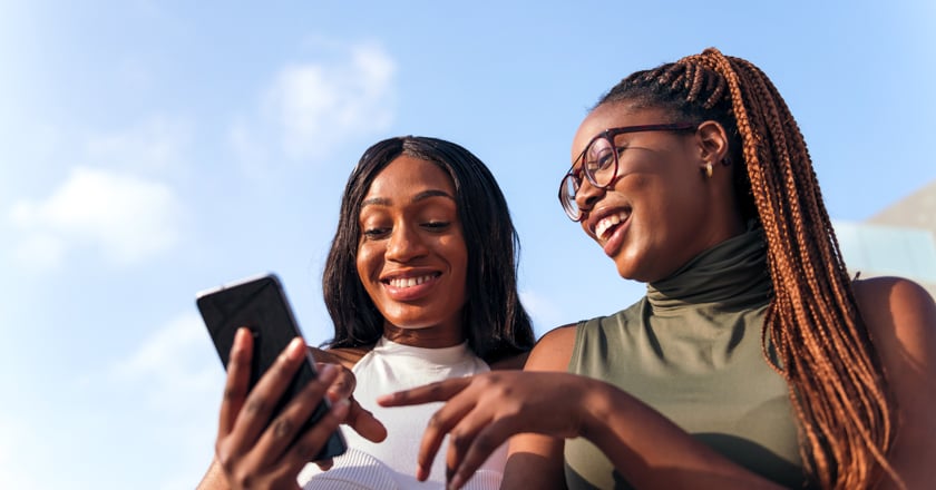 Two individuals looking at a cellphone.