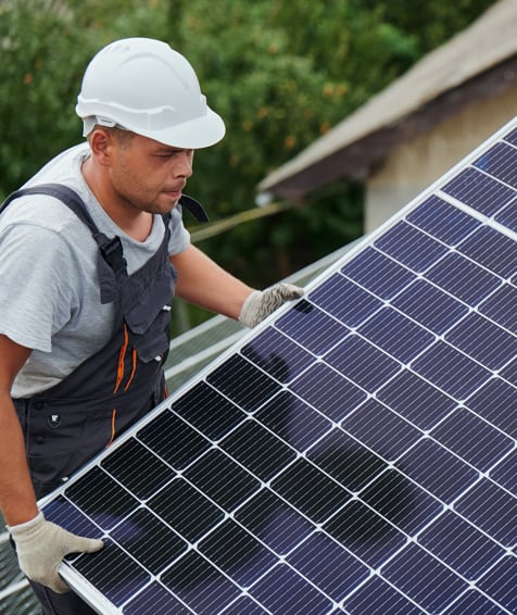 Individual installing solar panel on a roof.