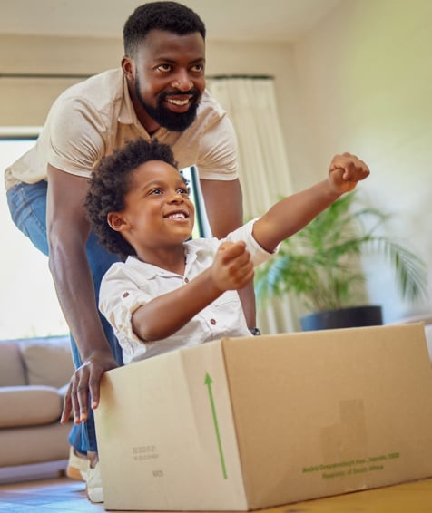 Individual and their child playing with moving boxes.