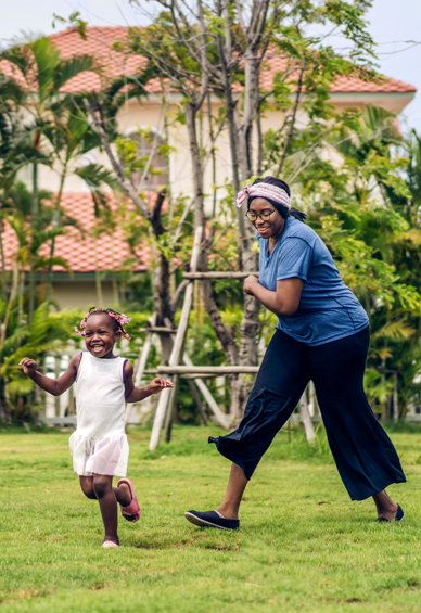 Individual and their child playing in back yard.