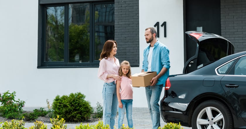 Individuals taking out moving boxes from their car. 